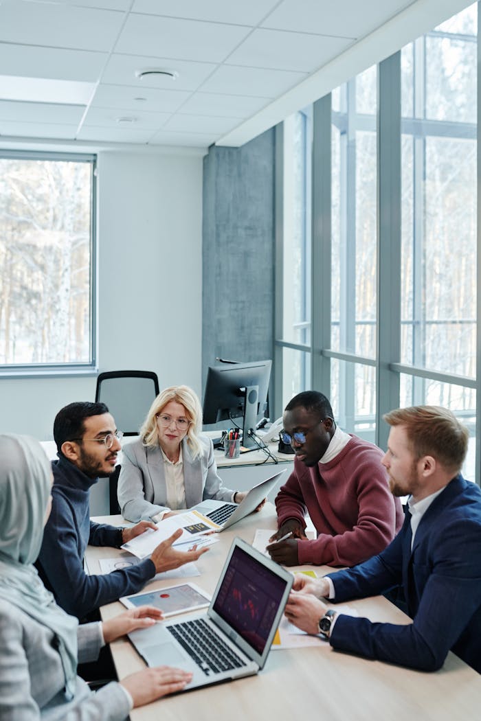A diverse group of colleagues working together on a project in a bright, modern office environment.